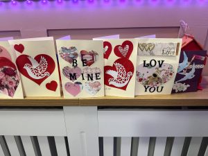 Handmade Valentine's Day cards with hearts and doves on display.