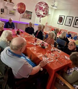 Seniors celebrating Valentines Day 2024 at a festive, decorated table.